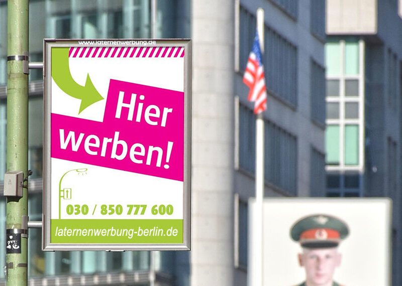 Laternenwerbung in Berlin am Checkpoint Charly
